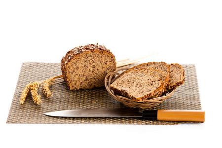 面包切片机在白色的大面包面包切大面包的全麦面包切成薄片木面包板上