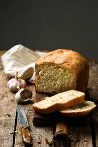 大面包的全麦面包切成薄片木面包板上大面包切片机法国法式面包的特写